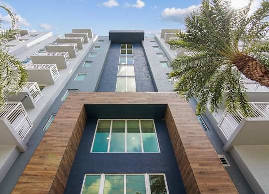 A tall apartment building with a modern entrance at Blue Lagoon 7 Apartments in Miami, FL