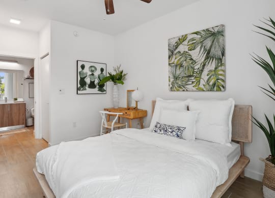 a bedroom with white walls and a white bed with white bedding