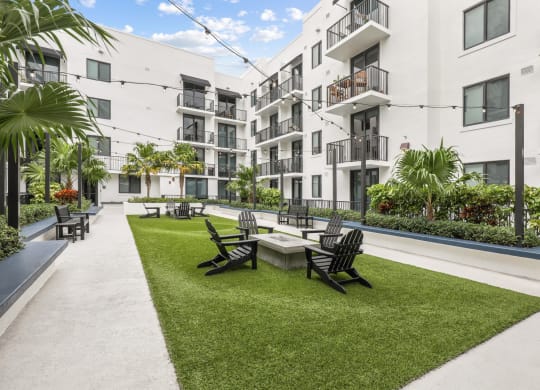 a courtyard with a table and chairs in front of some apartments