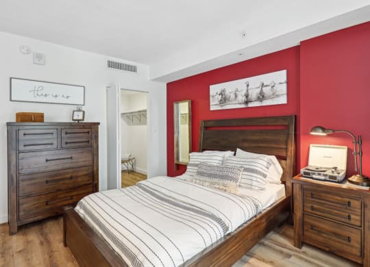 a bedroom with a bed and red walls and wooden furniture