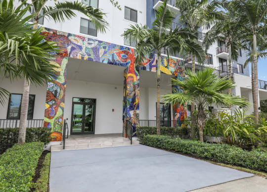 One of the entrances to our community with mural designs and palm trees at Bay Village 1 in Palmetto Bay, FL