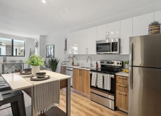 A kitchen with stainless steel appliances and a dining table at Bay Village 1 Apartment in Palmetto Bay, FL
