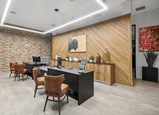 an office with a desk and chairs and a wall with a painting
