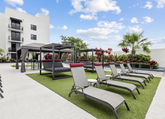 a row of lounge chairs and umbrellas in front of a building