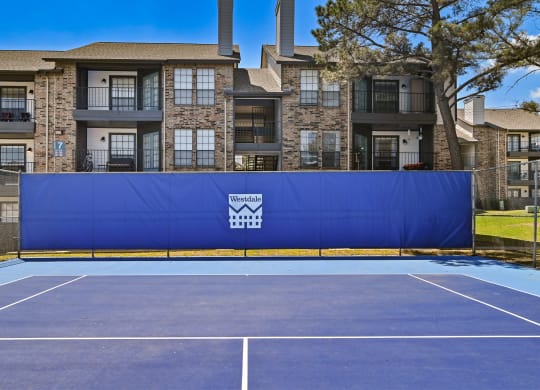 an outdoor tennis court at the enclave at woodbridge apartments in sugar land, tx