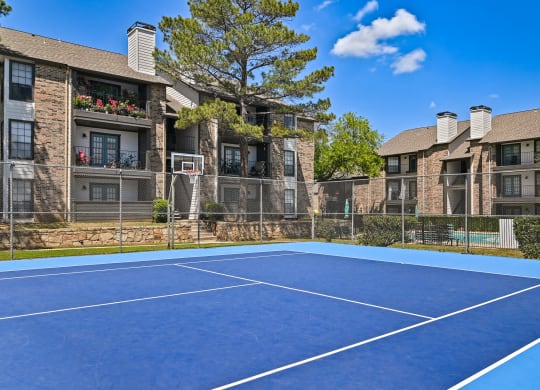 an outdoor tennis court at the enclave at woodbridge apartments in sugar land, tx