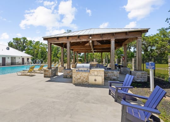 Grilling station at the pool area with seating at Capital Grand Apartments in Tallahassee, FL