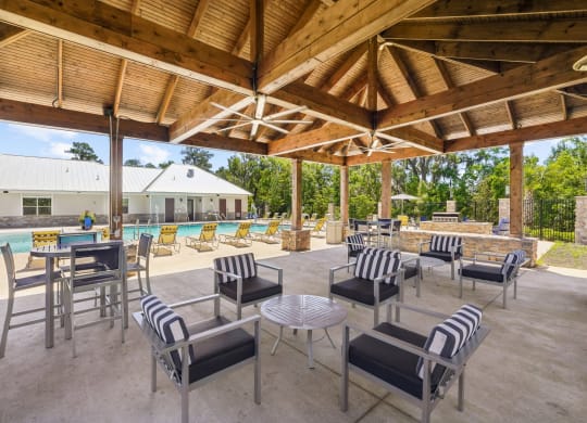 Shaded outdoor seating by the pool at Capital Grand Apartments in Tallahassee, FL