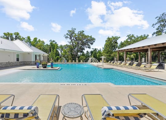 Sparkling swimming pool with lounge chairs at Capital Grand Apartments in Tallahassee, FL