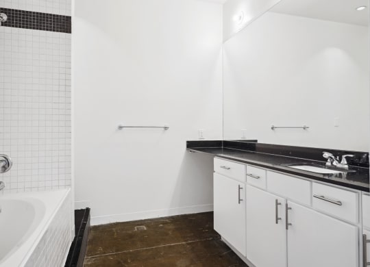 Loft bathroom at the Continental Building with white cabinets and tub | Continental Building Lofts from Deep Ellum Lofts in Dallas, TX
