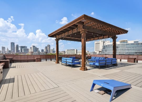 Rooftop Patio overlooking Dallas with cornhole boards and blue lounge patio couches | Continental Building Lofts from Deep Ellum Lofts in Dallas, TX