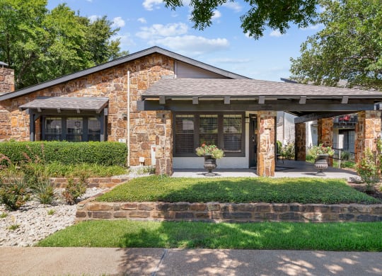 a home with stone exterior and a green lawn