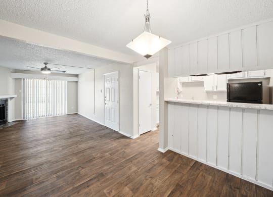 an open living room and kitchen with hardwood flooring