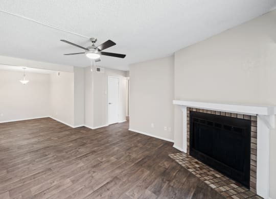 a living room with a fireplace and a ceiling fan
