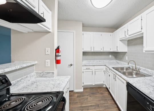 a kitchen with white cabinets and a black stove top oven