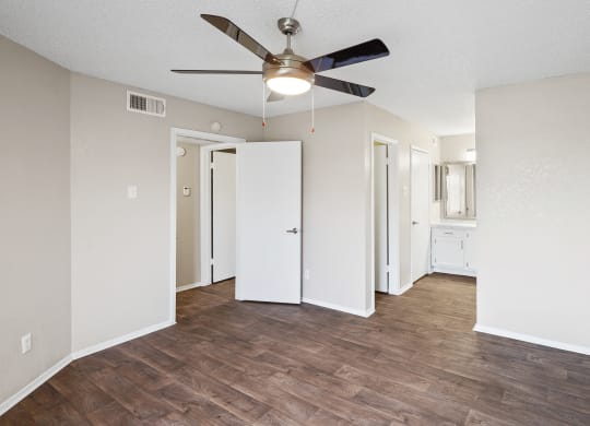 a bedroom with hardwood flooring and a ceiling fan