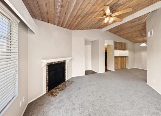 a living room with a fireplace and ceiling with a wooden ceiling