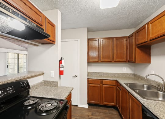 a kitchen with wood cabinets and granite countertops