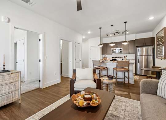 A modern living room with a dining area in the background.