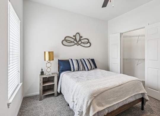 B3 bedroom with a bed, nightstand, and a ceiling fan at Creekside on Parmer Lane Apartments in Austin, TX