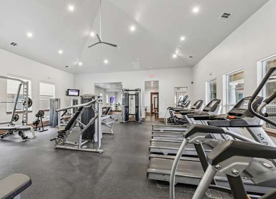 A fitness center with treadmills, weights, and strength training equipment at Creekside on Parmer Lane Apartments in Austin, TX