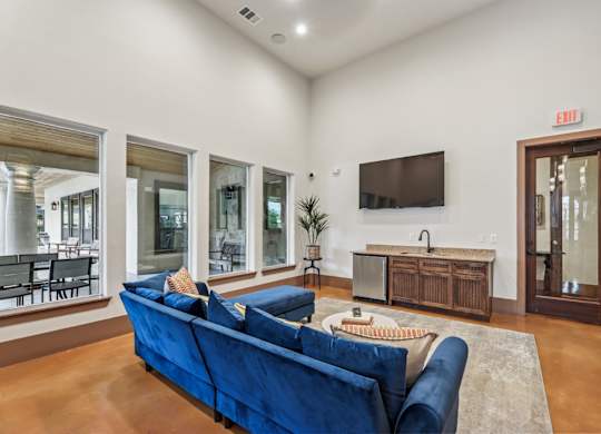 A resident lounge with a flat screen TV mounted on the wall at Creekside on Parmer Lane Apartments in Austin, TX