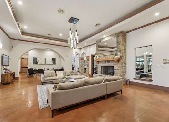A resident lounge with  a large sofa and stone fireplace at Creekside on Parmer Lane Apartments in Austin, TX
