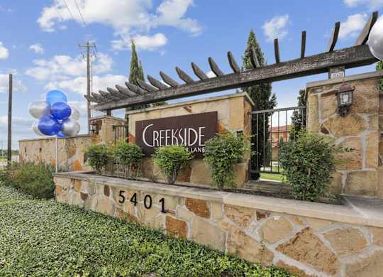 A stone sign for Creekside on Parmer Lane Apartments in Austin, TX