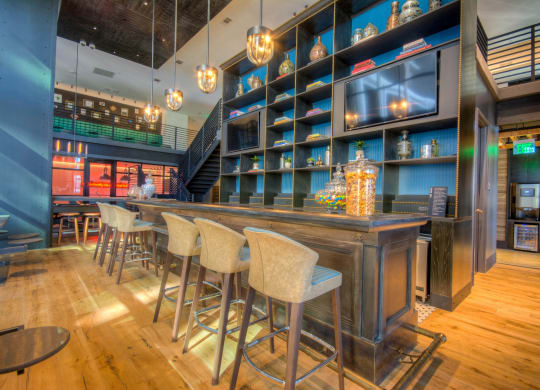 Apartment building on-site bar for residents with chairs at The Case Building in Dallas, TX
