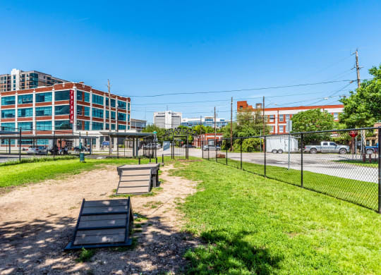 a park with a fence and a bench in front of a building