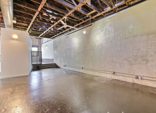 a large empty room with a concrete floor and a white wall