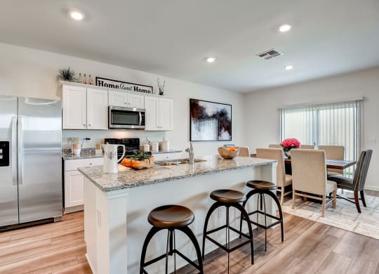 the kitchen and dining area of a modern home with stainless steel appliances