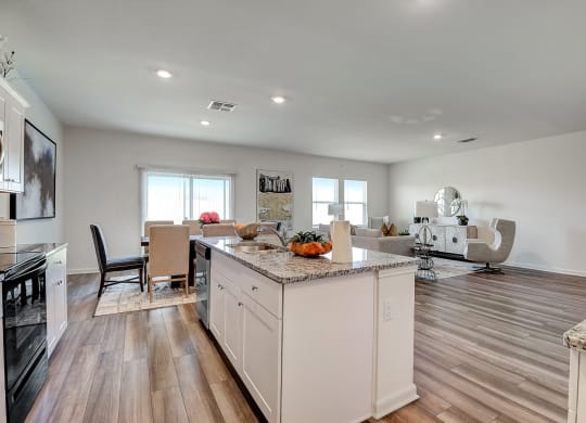 a kitchen with an island and a living room with a dining room
