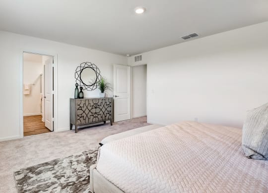 master bedroom with carpet floor, a mirror and a dresser