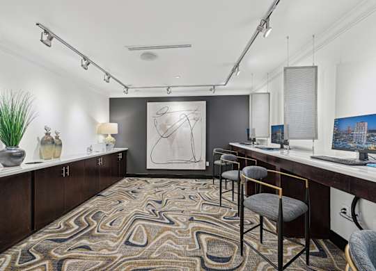 Sleek business center with 3 computers in frame at Dominion Post Oak apartments in Houston, TX