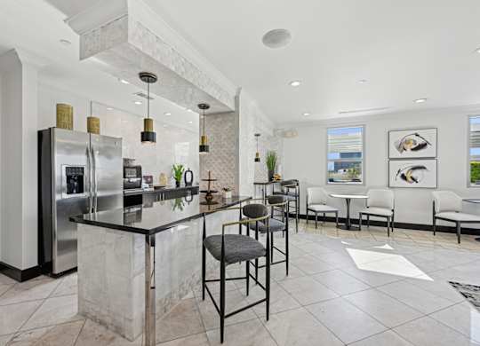 Modern community kitchen with an island and stainless steel appliances for all residents to enjoy at Dominion Post Oak apartments in Houston, TX
