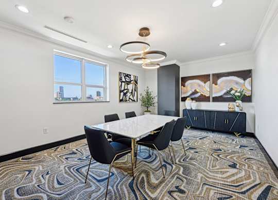 Conference room with long table and seats and window looking out to city at Dominion Post Oak apartments in Houston, TX
