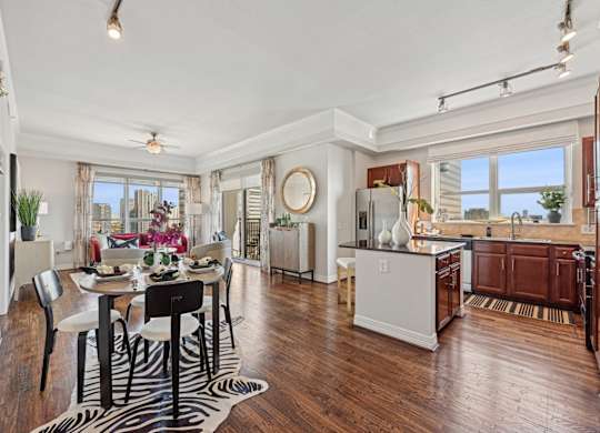 Model kitchen and dining room with a zebra print rug and under the dining table at Dominion Post Oak apartments in Houston, TX