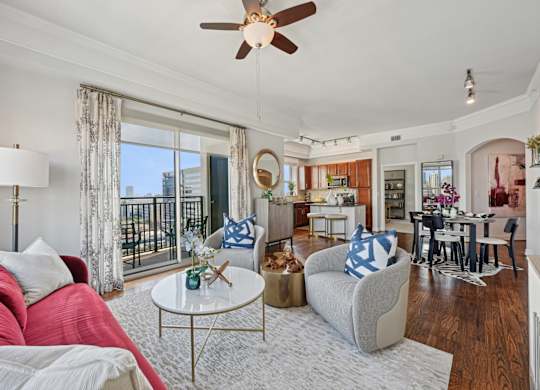 Model apartment living room with a red couch and a white coffee table at Dominion Post Oak apartments in Houston, TX
