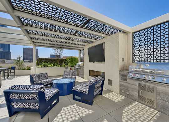 Outdoor grilling station with BBQ grill and seating at Dominion Post Oak apartments in Houston, TX