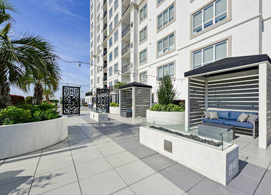 Relaxing outdoor cabanas with firepits in front at Dominion Post Oak apartments in Houston, TX