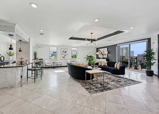 Spacious resident lounge with a kitchen area in the background at Dominion Post Oak apartments in Houston, TX