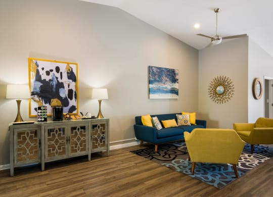 resident lounge with a blue couch and yellow chairs at Dunwoody Pointe in Sandy Springs, GA