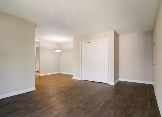 an empty living room with a hardwood floor and white walls at Dunwoody Pointe in Sandy Springs, GA