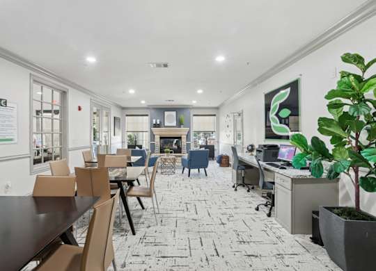A business center with computers, tables and chairs, and a printer at Encore at Buckingham Apartments in Richardson, TX