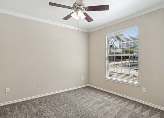 Edinburgh bedroom with a ceiling fan and a window at Encore at Buckingham Apartments in Richardson, TX
