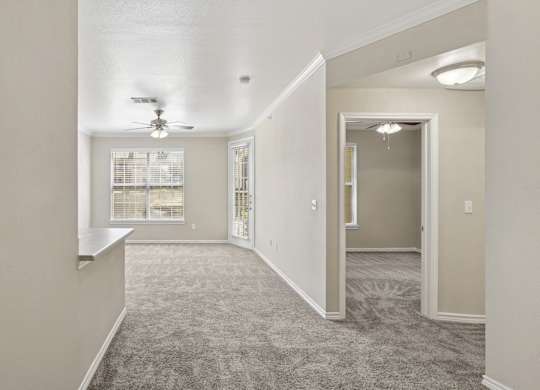Edinburgh living room  with a carpeted floor and a ceiling fan at Encore at Buckingham Apartments in Richardson, TX
