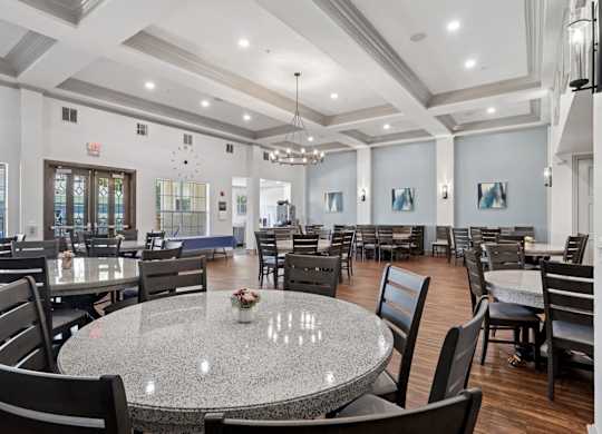 A large event room with round tables and chairs at Encore at Buckingham Apartments in Richardson, TX