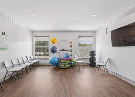 A fitness center with weights, yoga equipment, and a TV at Encore at Buckingham Apartments in Richardson, TX