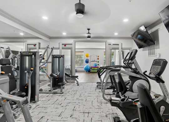 A fitness center with yoga balls and strength training equipment at Encore at Buckingham Apartments in Richardson, TX